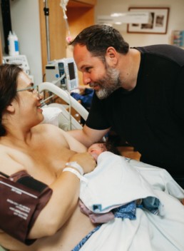 A beautiful mama and her loving husband and new son.