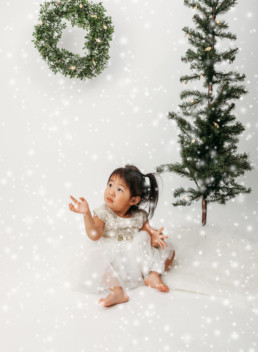 Toddler poses in snow for christmas themed photo