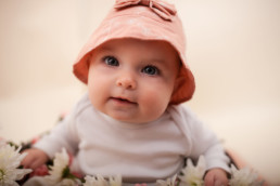 Baby sits for in studio photo shoot in Pasadena, California in a bucket of flowers