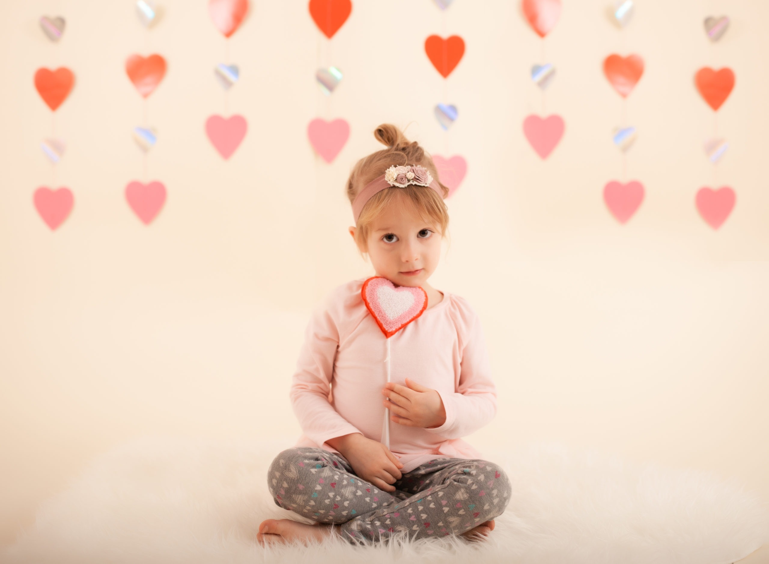 Toddler in studio photo shoot in Pasadena, California with valentine day themed props, heart backdrop