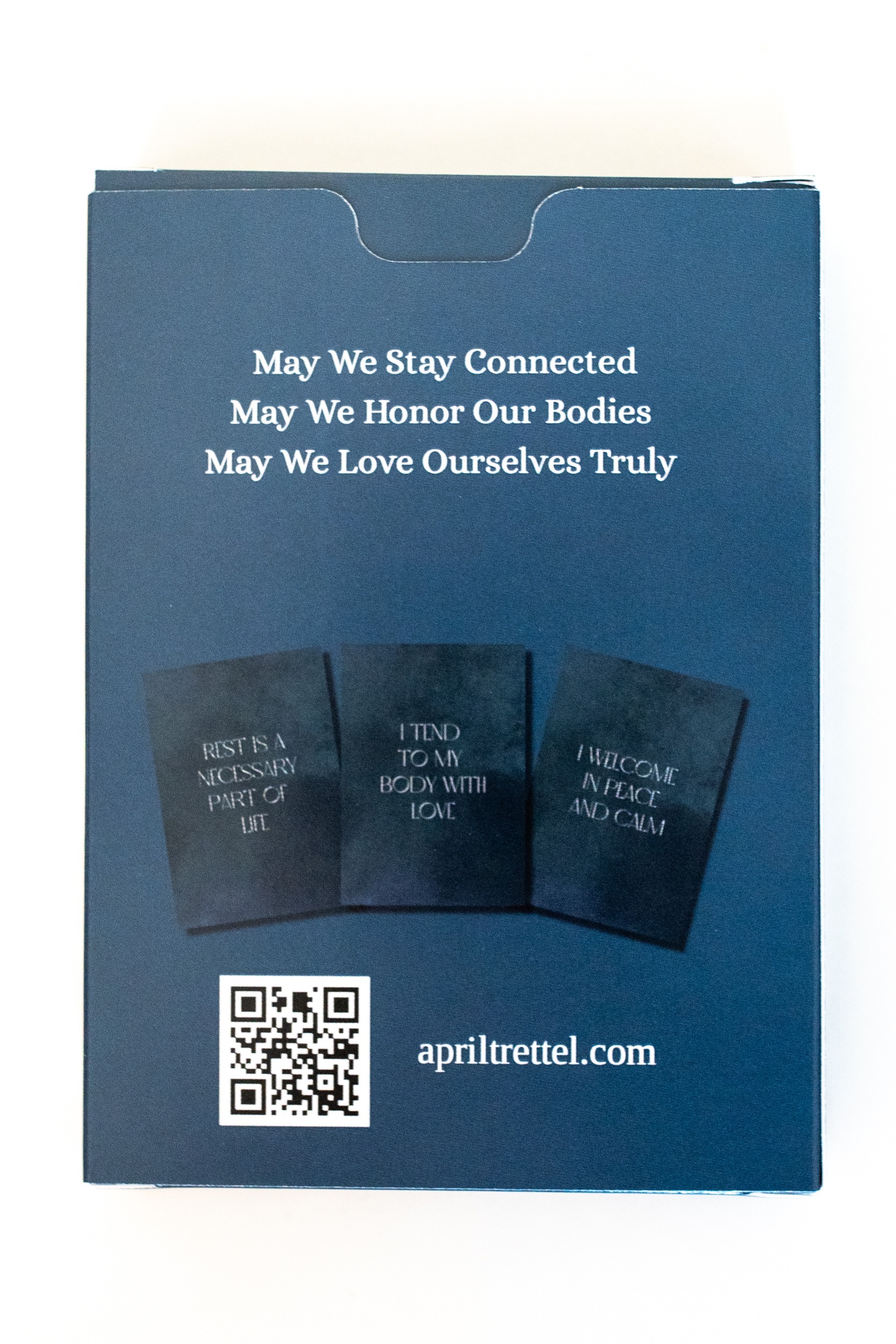 Photo of affirmation card deck entitled Encircled - period affirmation cards. Dark blue deck with golden flower pictured on the front